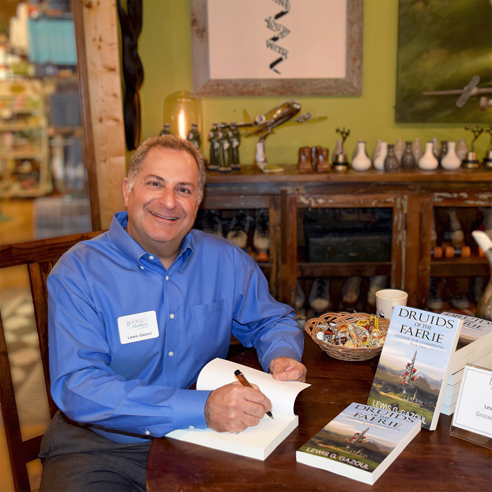 A photograph of Lewis Gazoul signing books at an event.